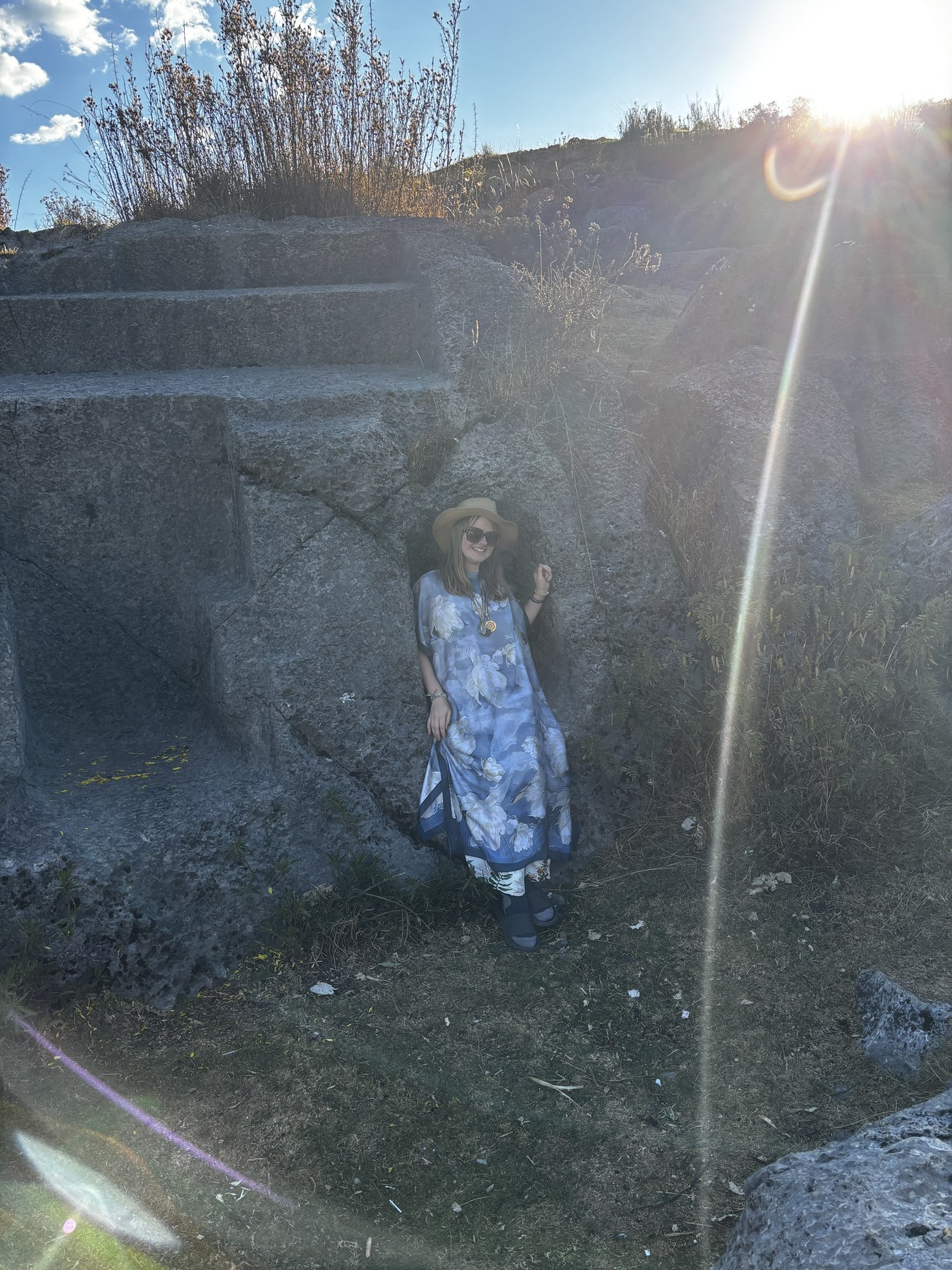 Georgia standing in a beam of prismatic sunlight among ancient stone